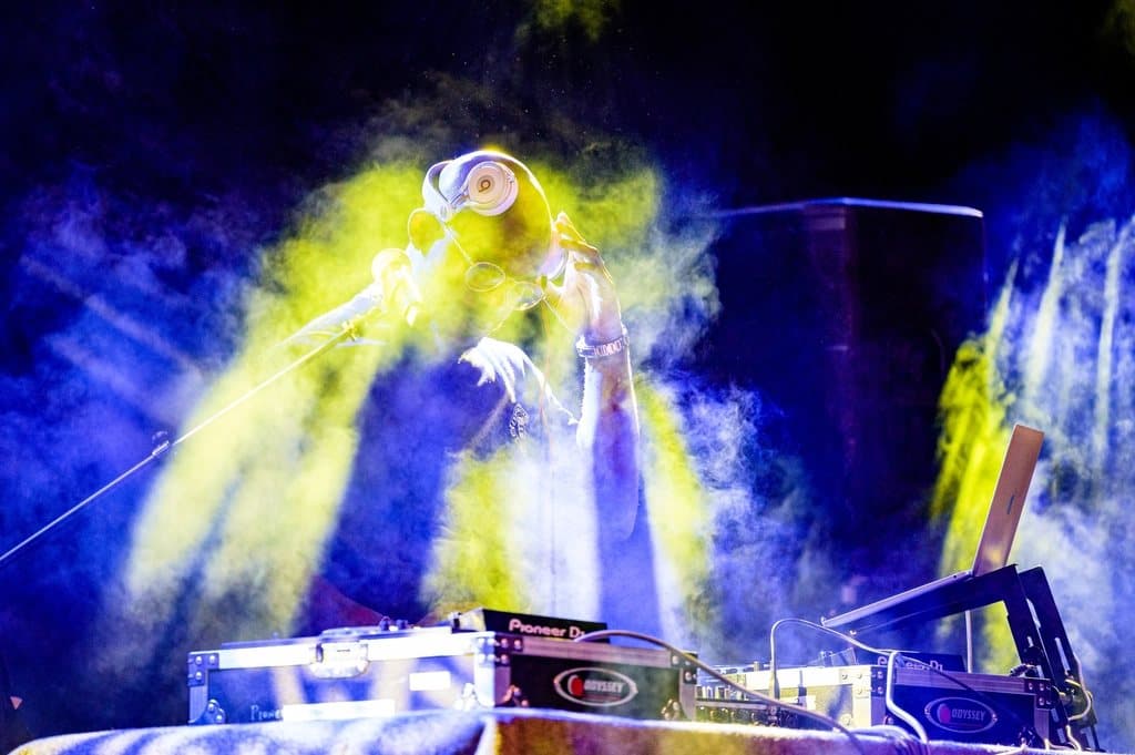 DJ playing in a night club with colorful lights