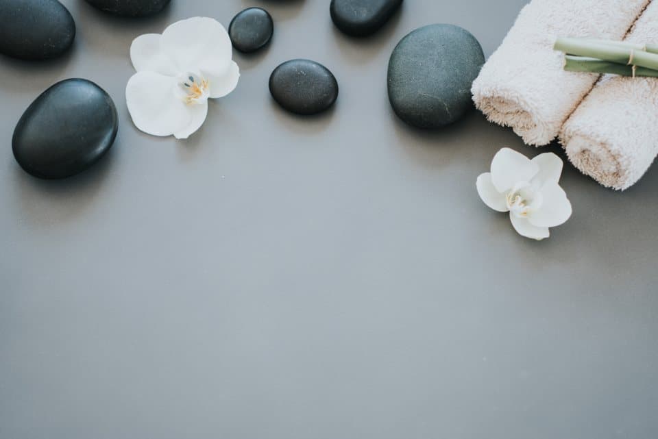 Massage room with soft lighting, white towels, and candles