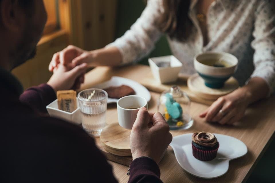 Casal conversando em uma cafeteria aconchegante
